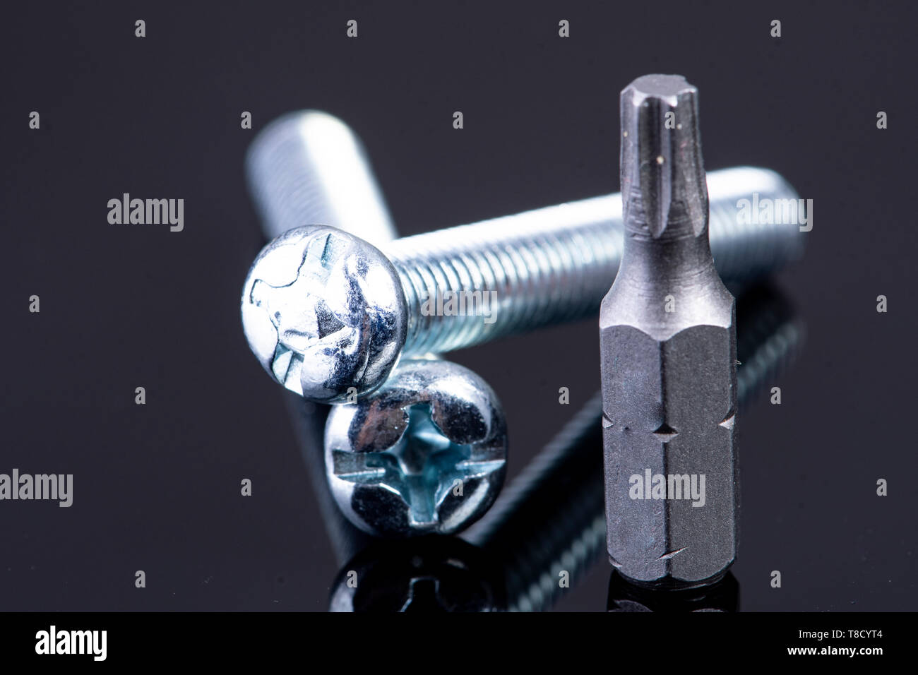 two screws with screws bit on black background Stock Photo