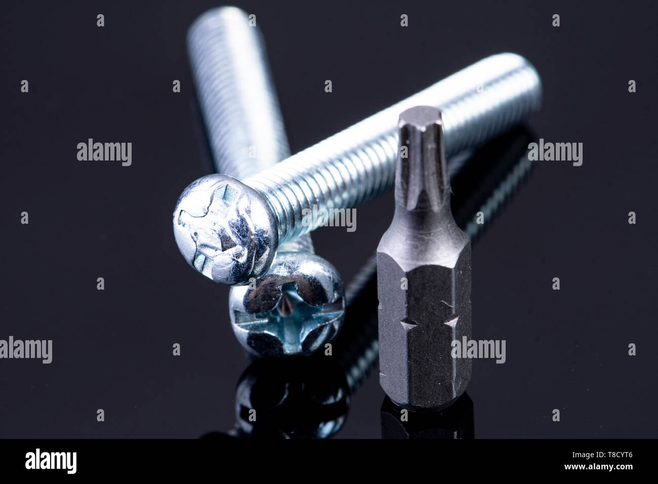 two screws with screws bit on black background Stock Photo