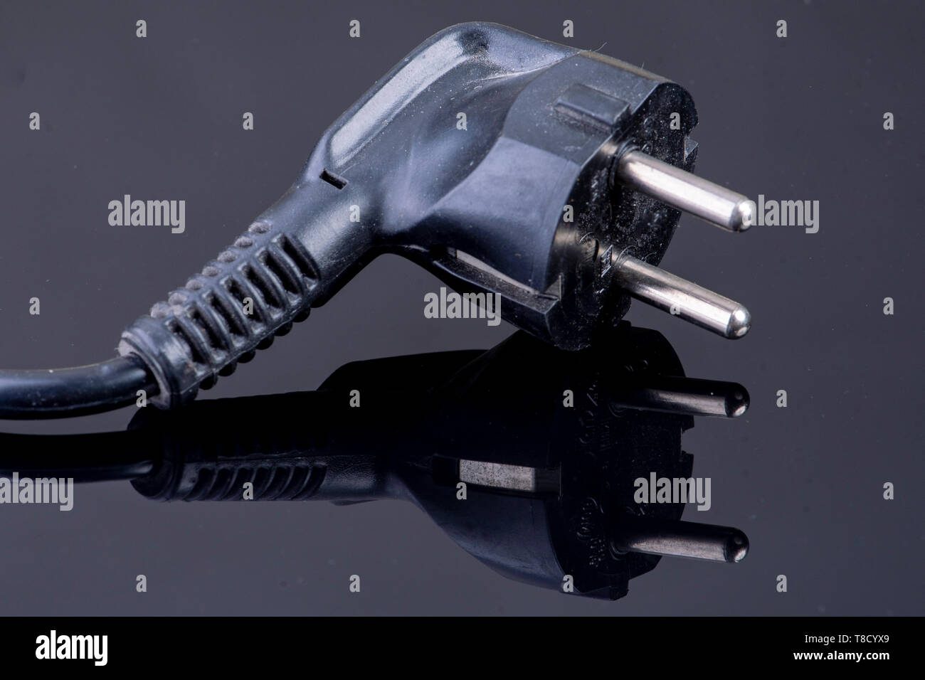 Power plug on reflective black surface Stock Photo