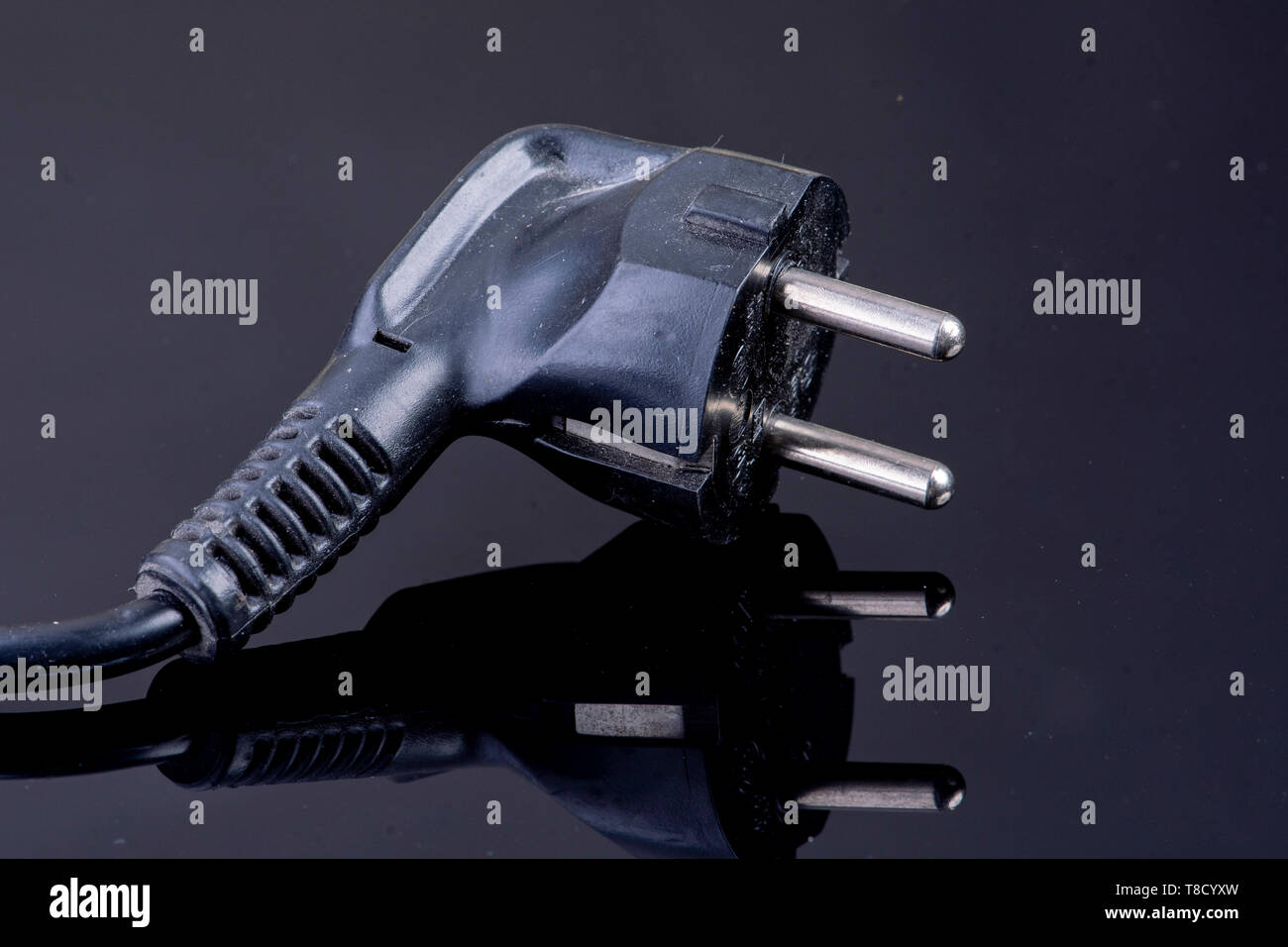 Power plug on reflective black surface Stock Photo