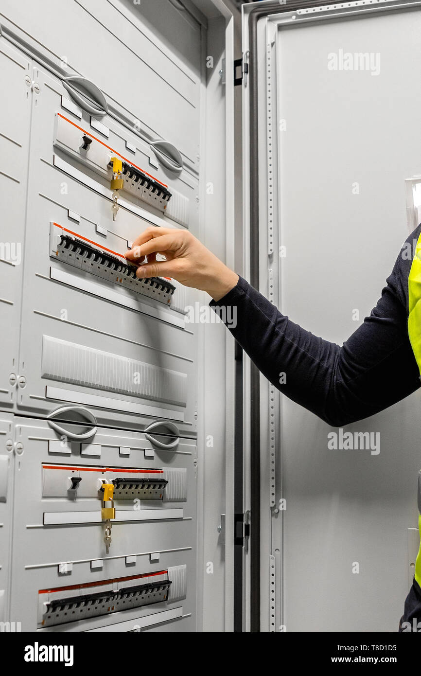 Male Electrician Checking Electric Fuse Board In Server Room Stock