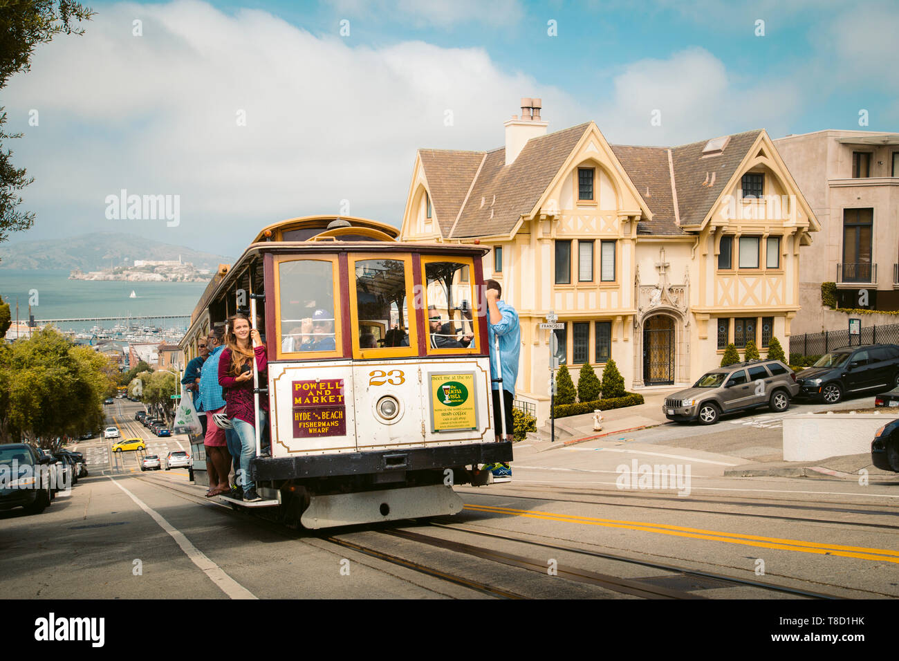 SEPTEMBER 3, 2016 - SAN FRANCISCO: Powell-Hyde cable car climbing up steep hill in central San Francisco with famous Alcatraz Island in the background Stock Photo
