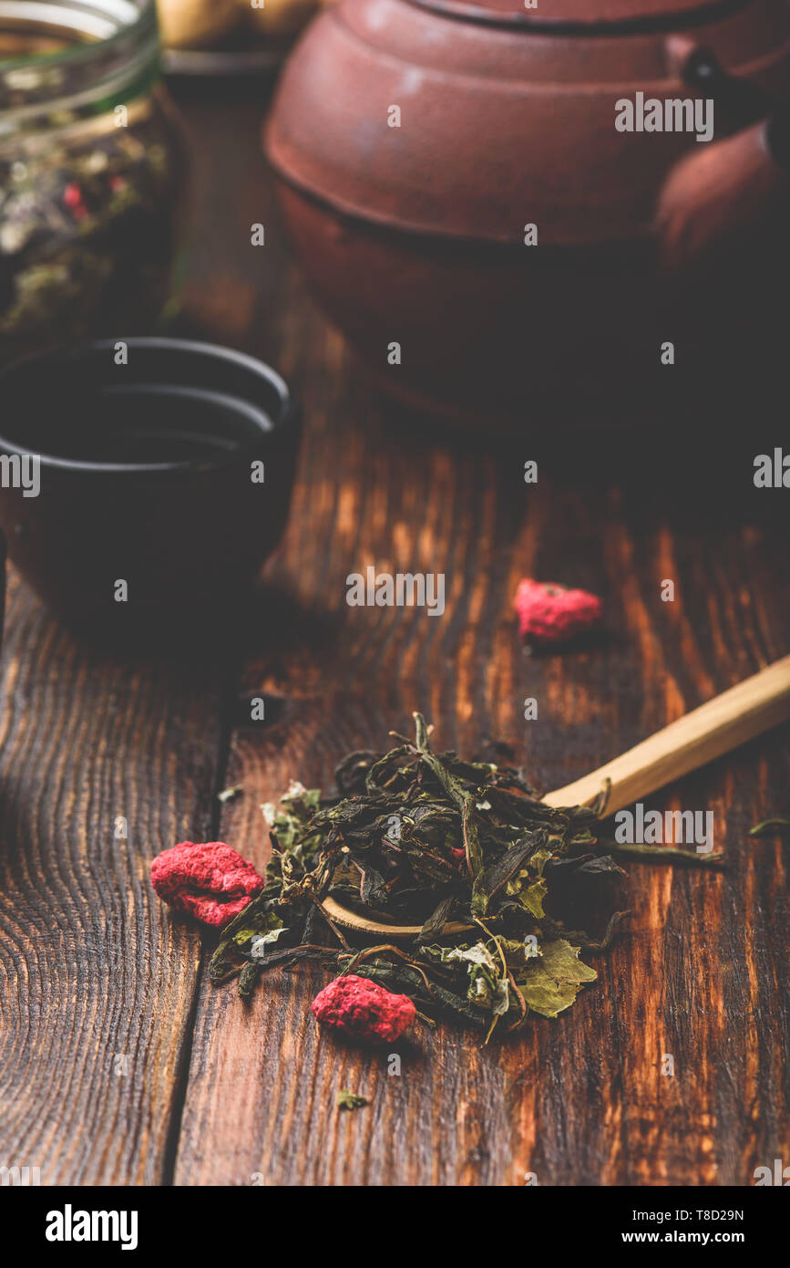 Cast iron tea bowls with teapot and wooden spoonful of raspberry herbal ...