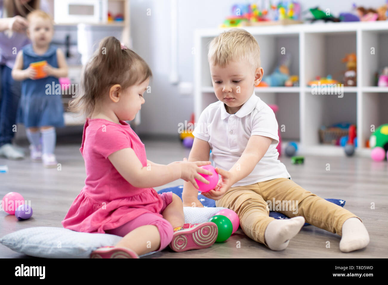 Little toddlers boy and a girl play together in nursery room. Preschool children in day care centre Stock Photo