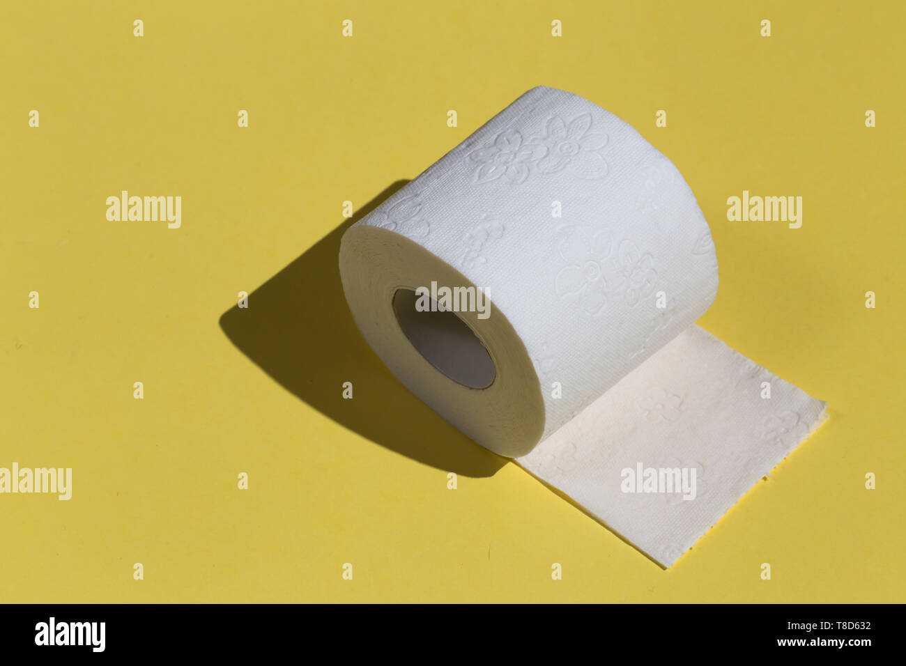 Roll of toilet paper or tissue isolated on yellow background. close up photo. copy space Stock