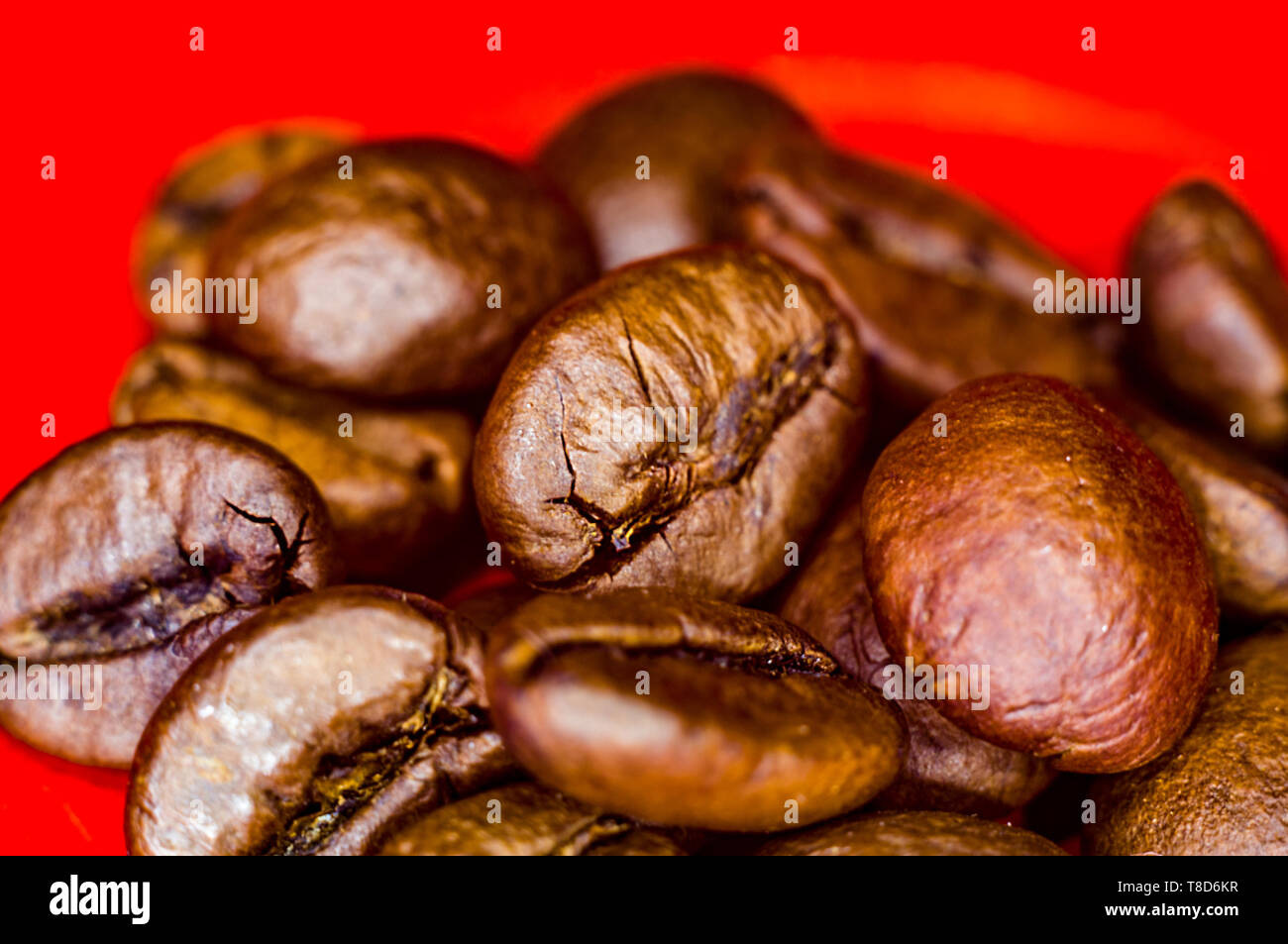 Brown roasted coffee beans on red background, close-up, macro Stock ...