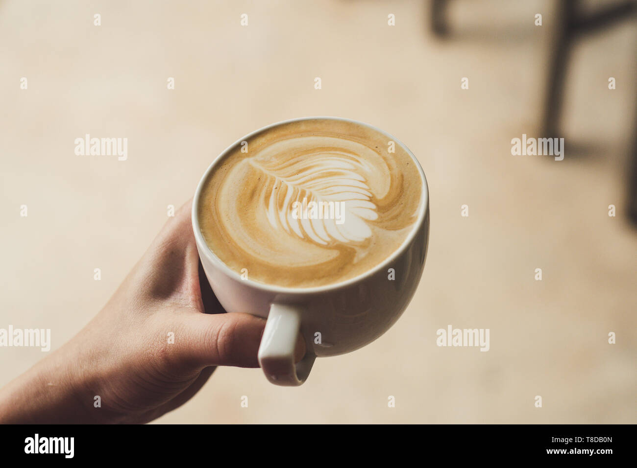 Closeup image of female barista holding latte art coffee Stock Photo