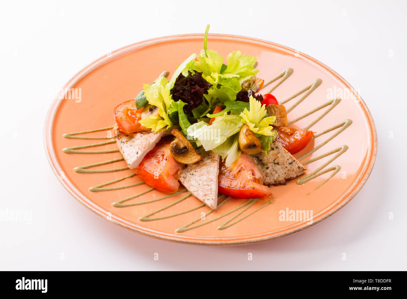 Warm Veal salad with tomato, mushrooms, lettuce, mushroom sauce and olive oil. Isolated on a white background. Stock Photo