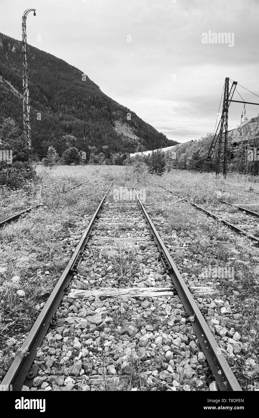 Railroad tracks pointed to the infinite at the abandoned Canfranc International railway station (Canfranc, Pyrenees, Huesca, Aragon,Spain) B&W version Stock Photo
