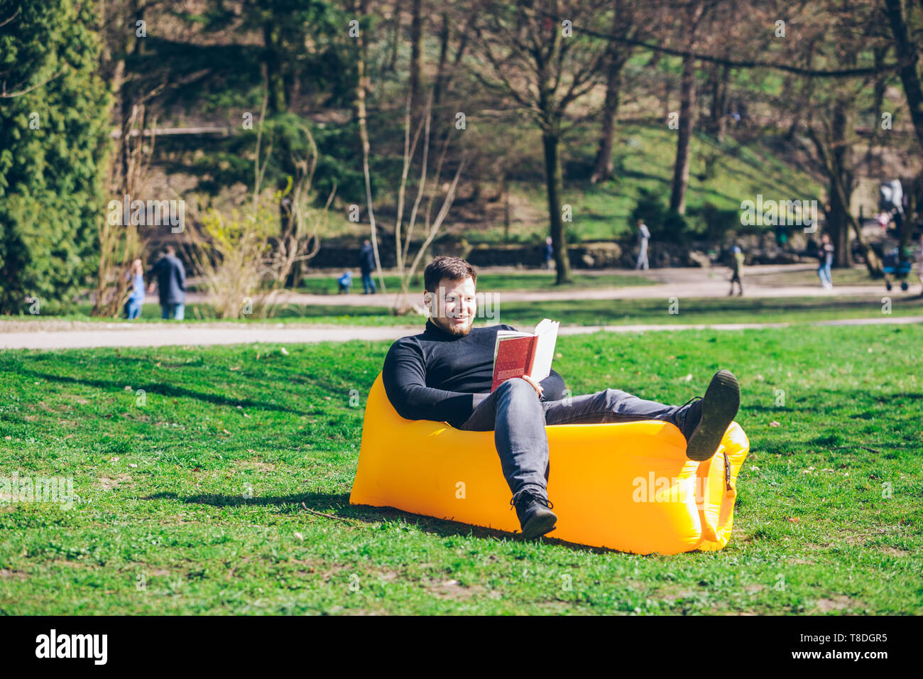Man Spring Reading book reading concept. man in city park on inflatable mattress. spring ...
