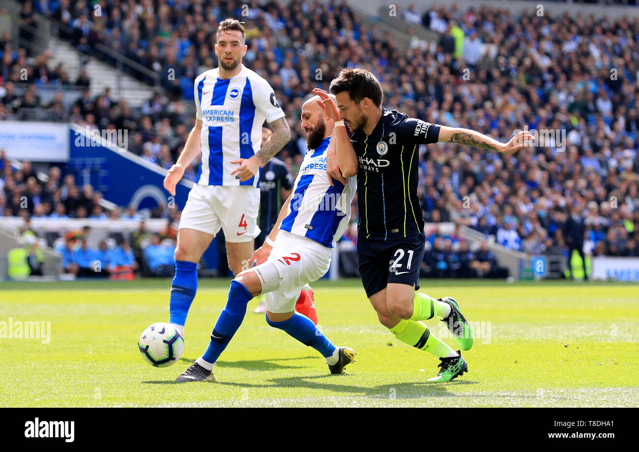 Brighton & Hove Albion's Bruno Saltor (left) and Manchester City's David Silva (right) battle for the ball during the Premier League match at the AMEX Stadium, Brighton. Stock Photo