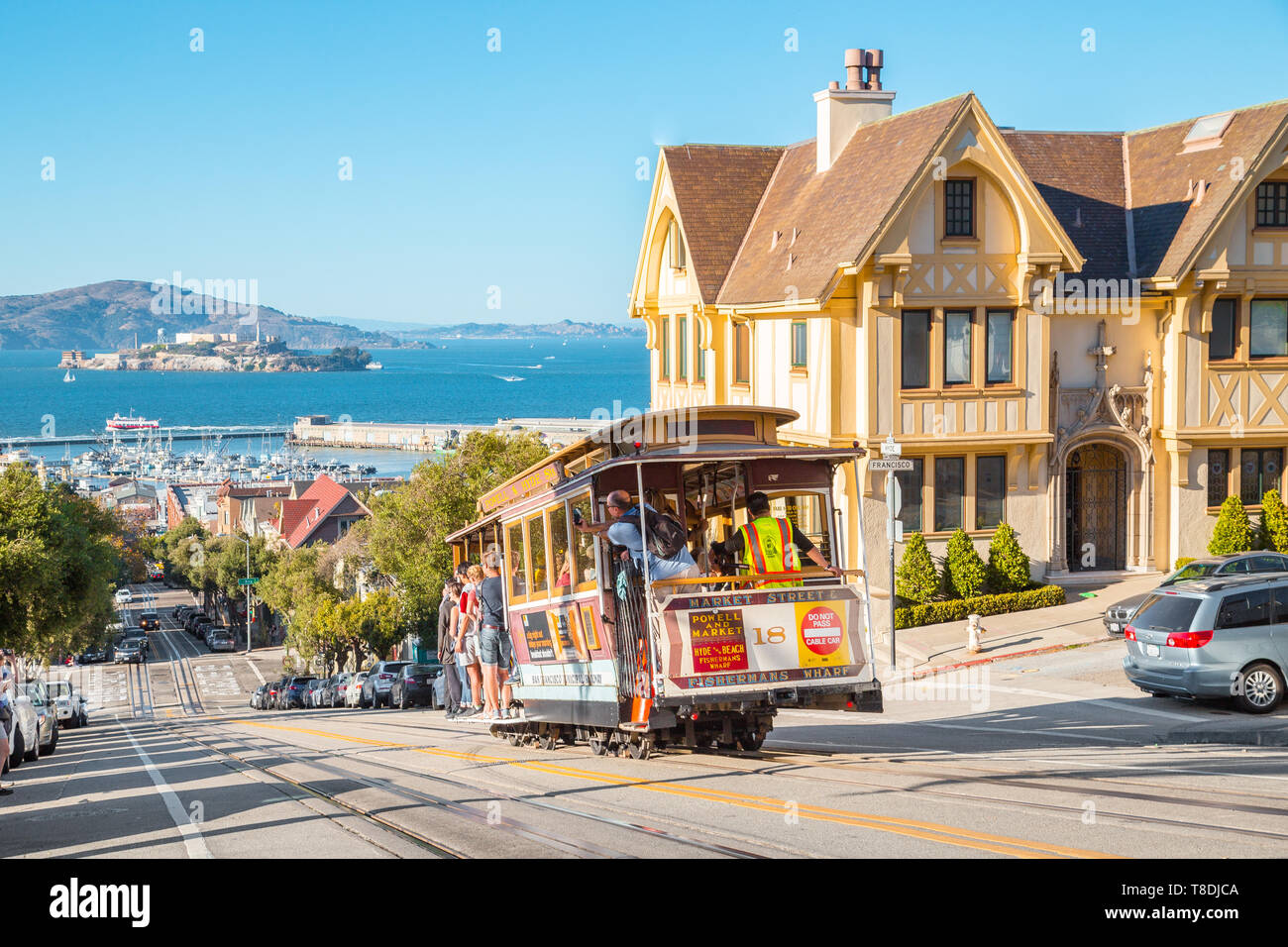 SAN FRANCISCO, USA - SEPTEMBER 25, 2016: Powell-Hyde cable car climbing up steep hill in central San Francisco with famous Alcatraz Island in the back Stock Photo