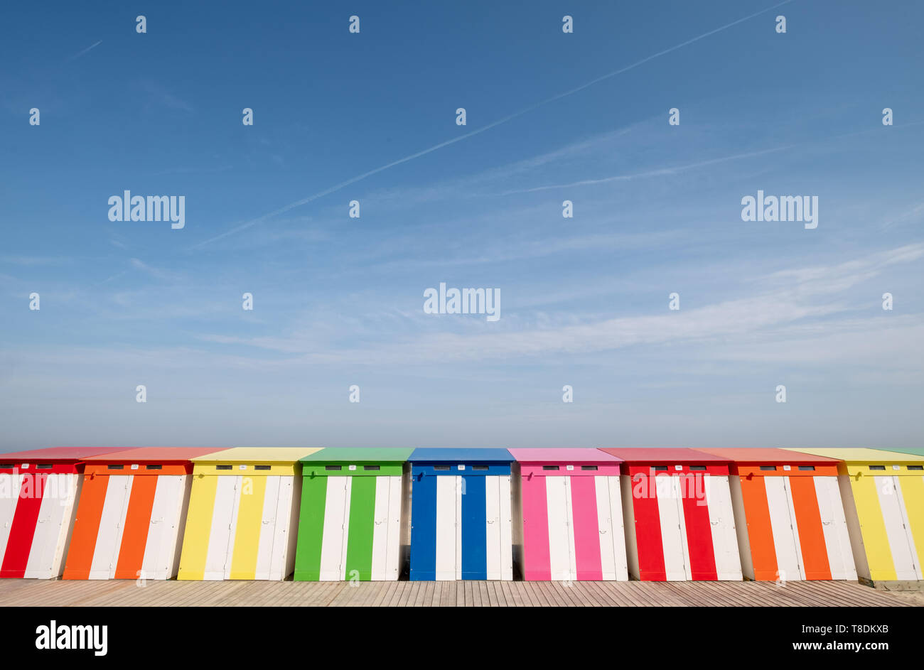 Dunkerque, France: Row of brightly coloured striped beach cabins on the sea front at Malo-Les-Bains beach in Dunkirk. Stock Photo