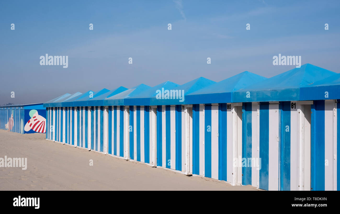 Blue and white striped beach huts on the sand on the sea front at Malo-Les-Bains beach in Dunkirk, France Stock Photo