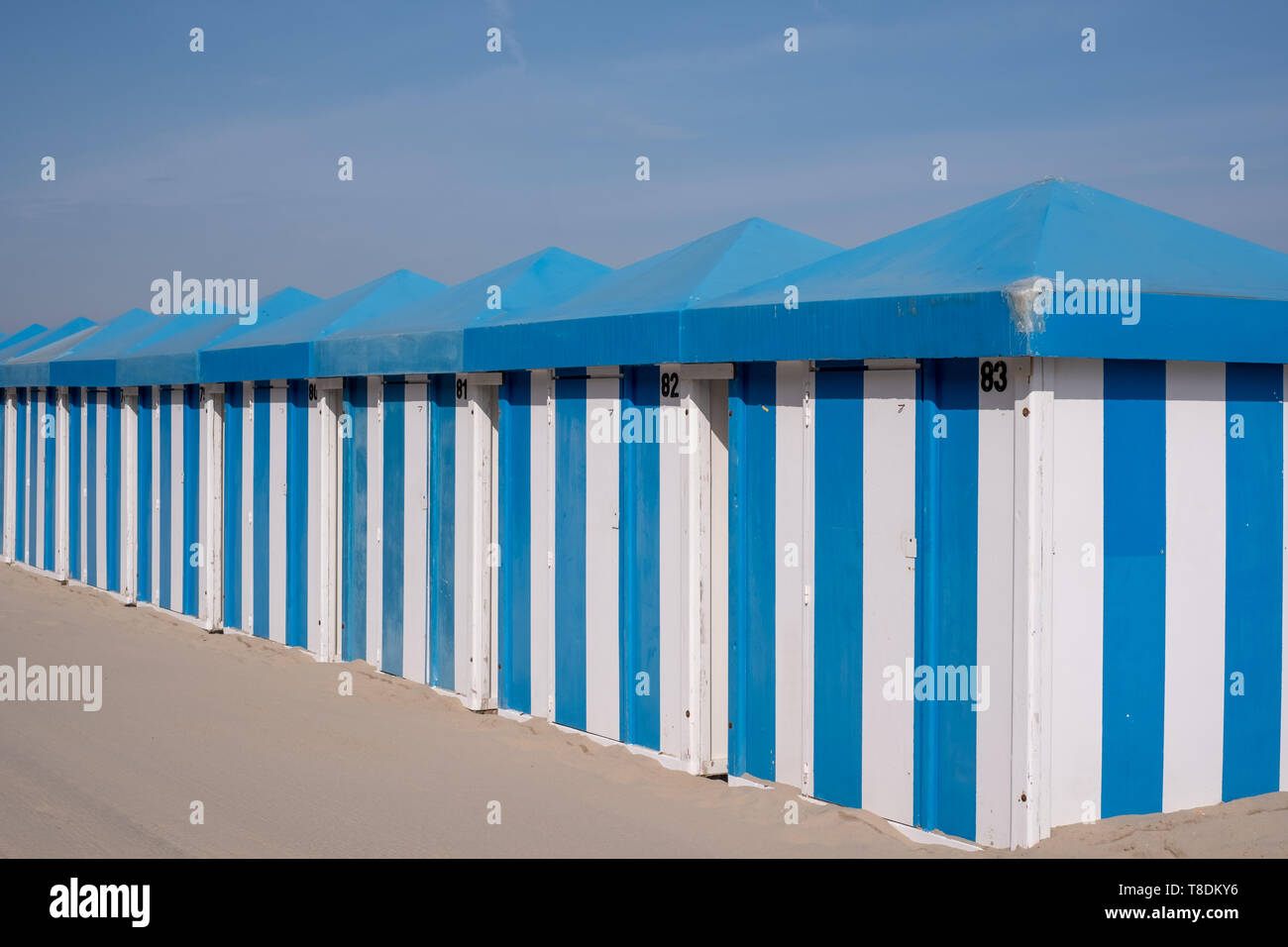 Blue and white striped beach huts on the sand on the sea front at Malo-Les-Bains beach in Dunkirk, France Stock Photo