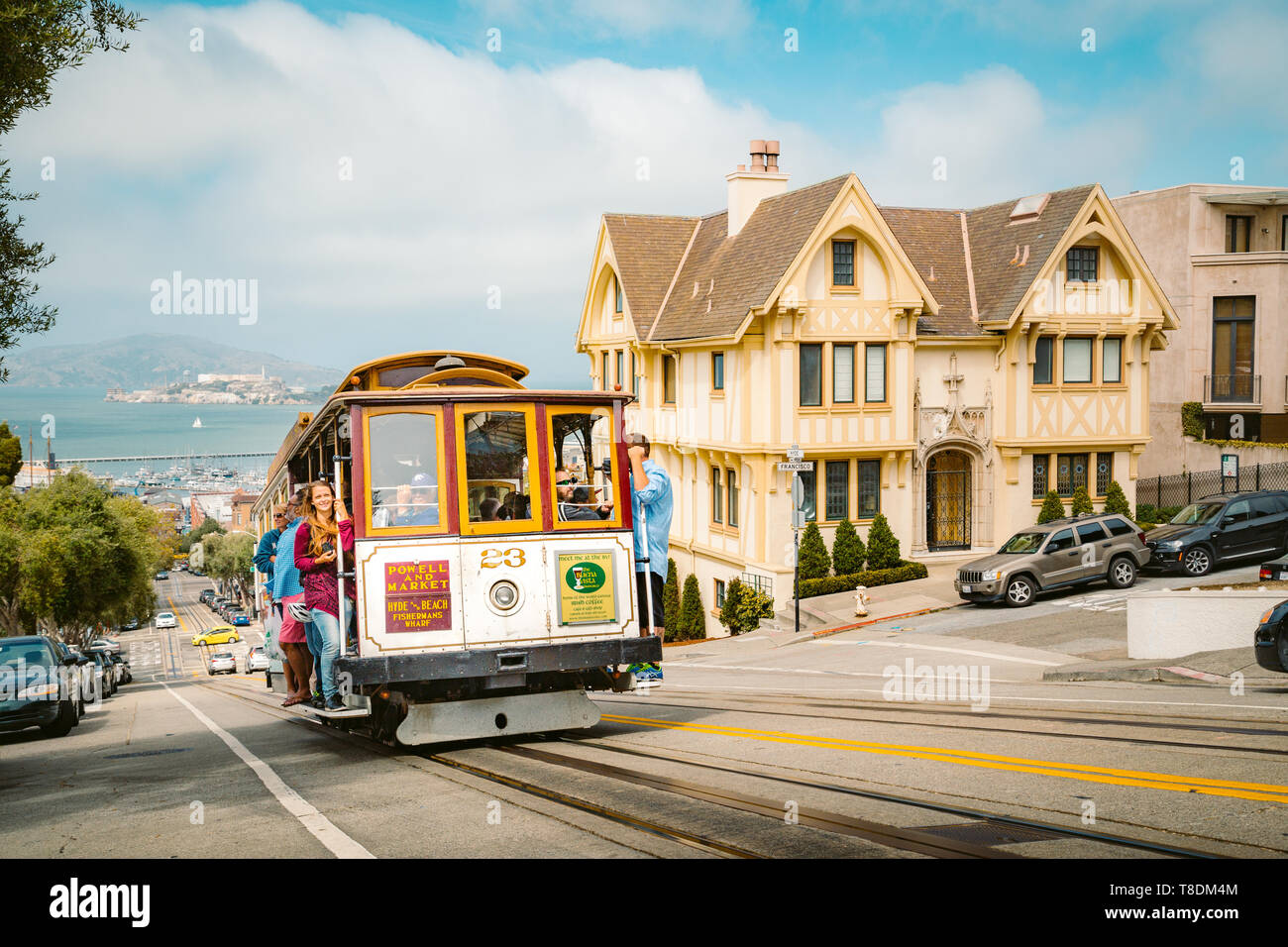 SAN FRANCISCO, USA - SEPTEMBER 3, 2016: Powell-Hyde cable car climbing up steep hill in central San Francisco with famous Alcatraz Island in the backg Stock Photo
