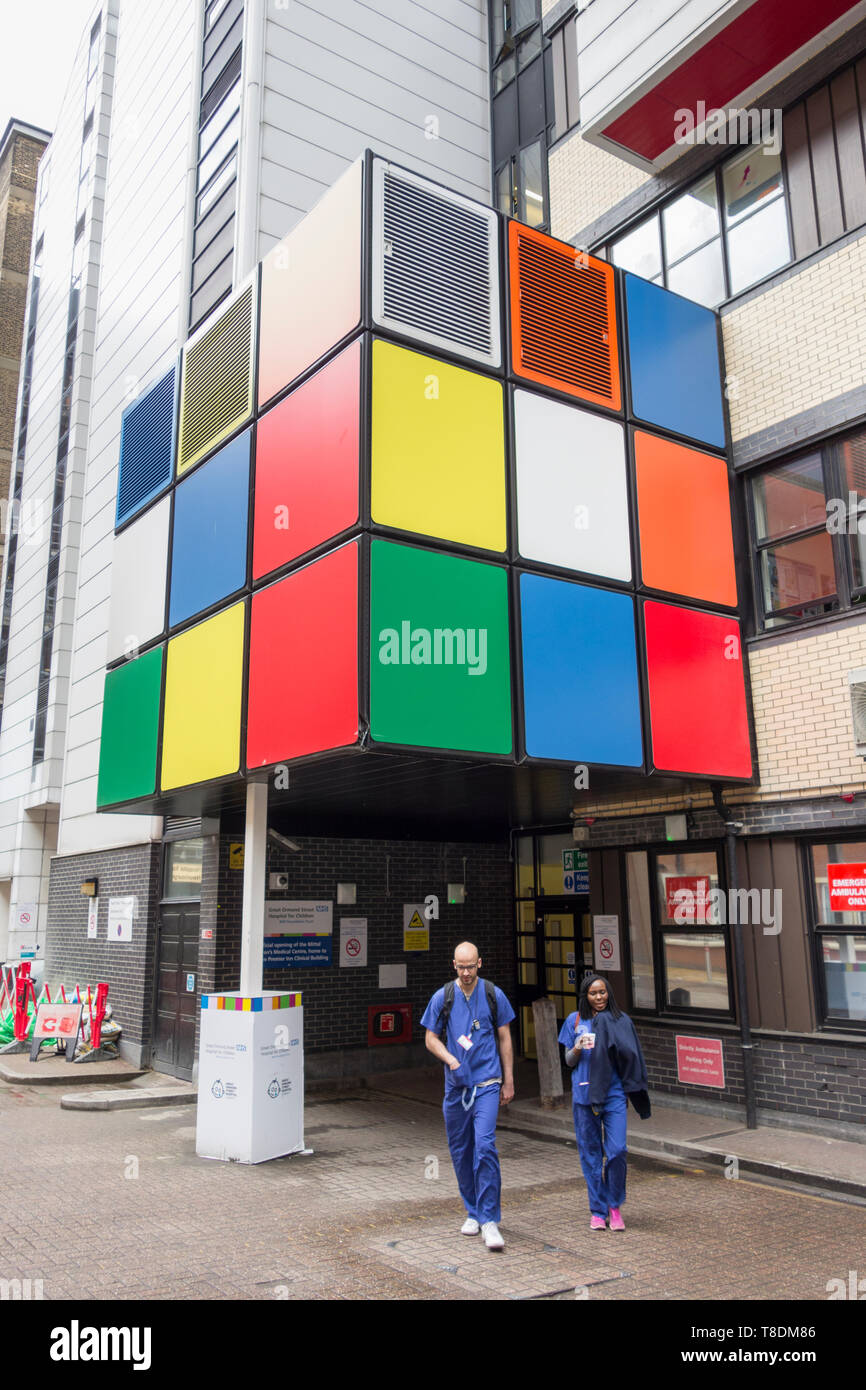 Doctors and a Rubik's cube type art installation outside Great Ormond Street Hospital in London, England, UK Stock Photo