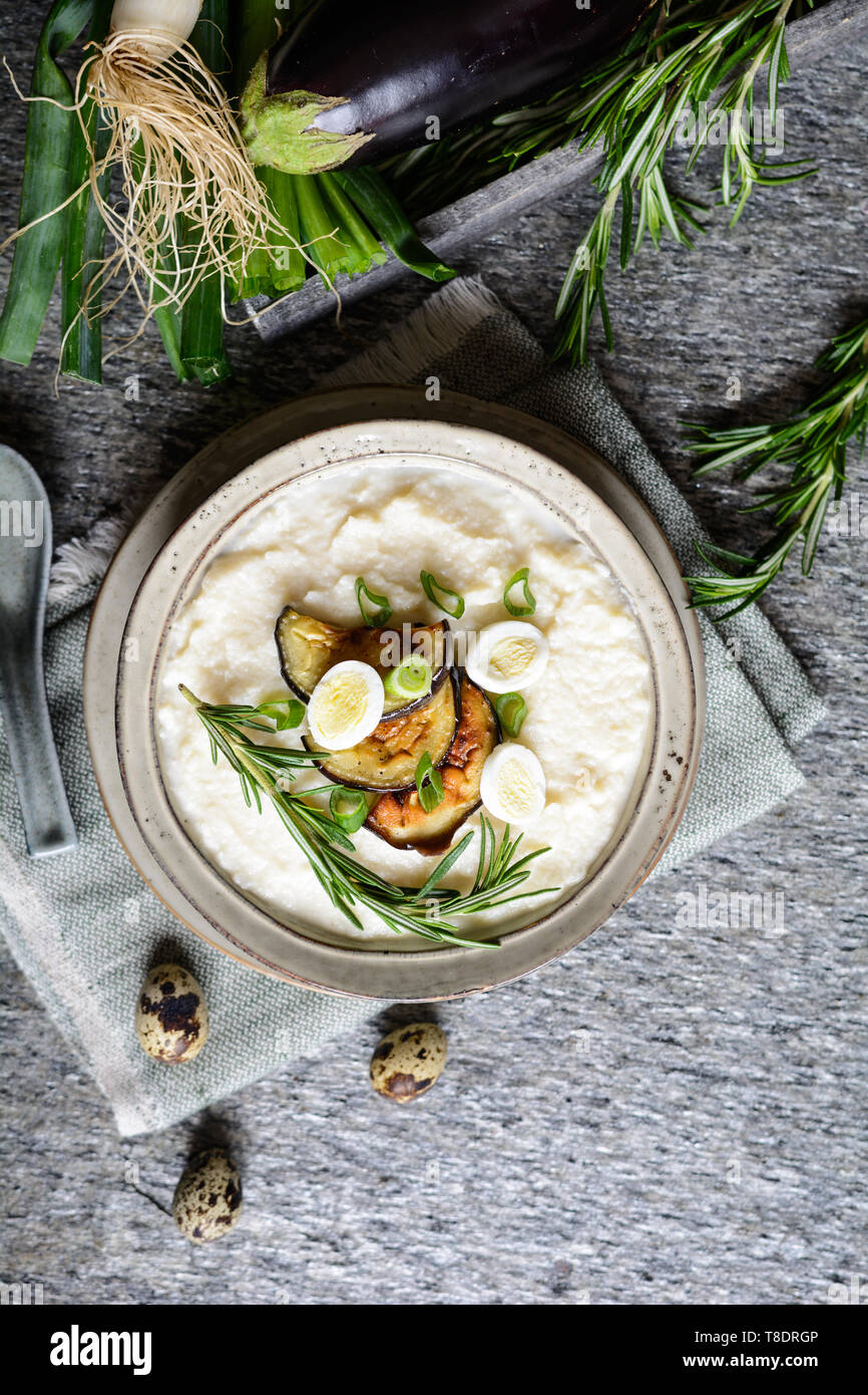 Delicious cauliflower puree with baked eggplant and quail eggs Stock Photo