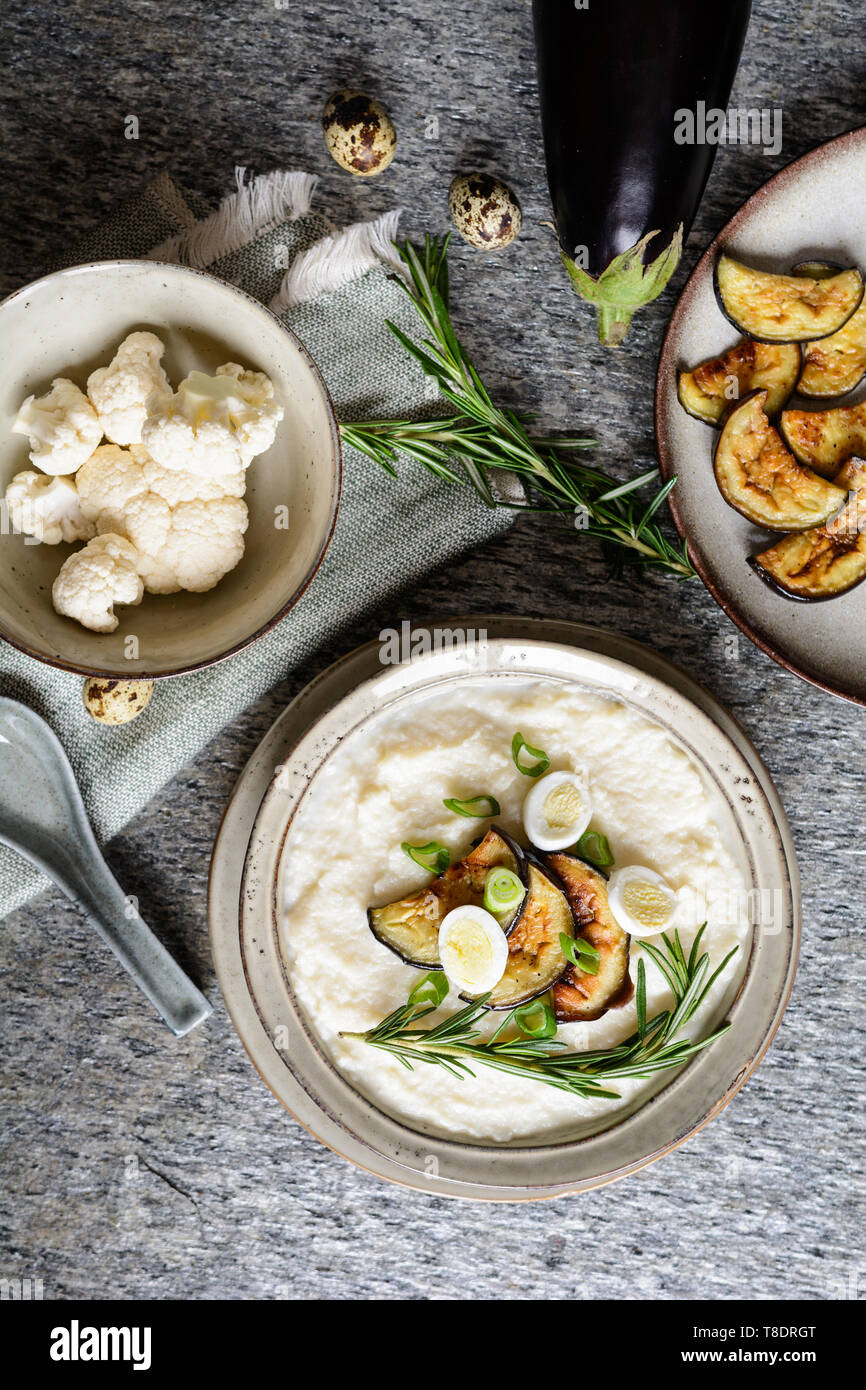 Delicious cauliflower puree with baked eggplant and quail eggs Stock Photo