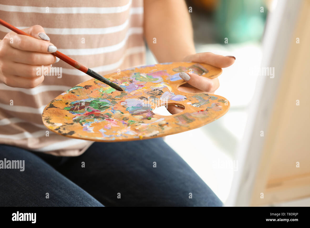 Female artist with brush and paint palette in workshop Stock Photo - Alamy