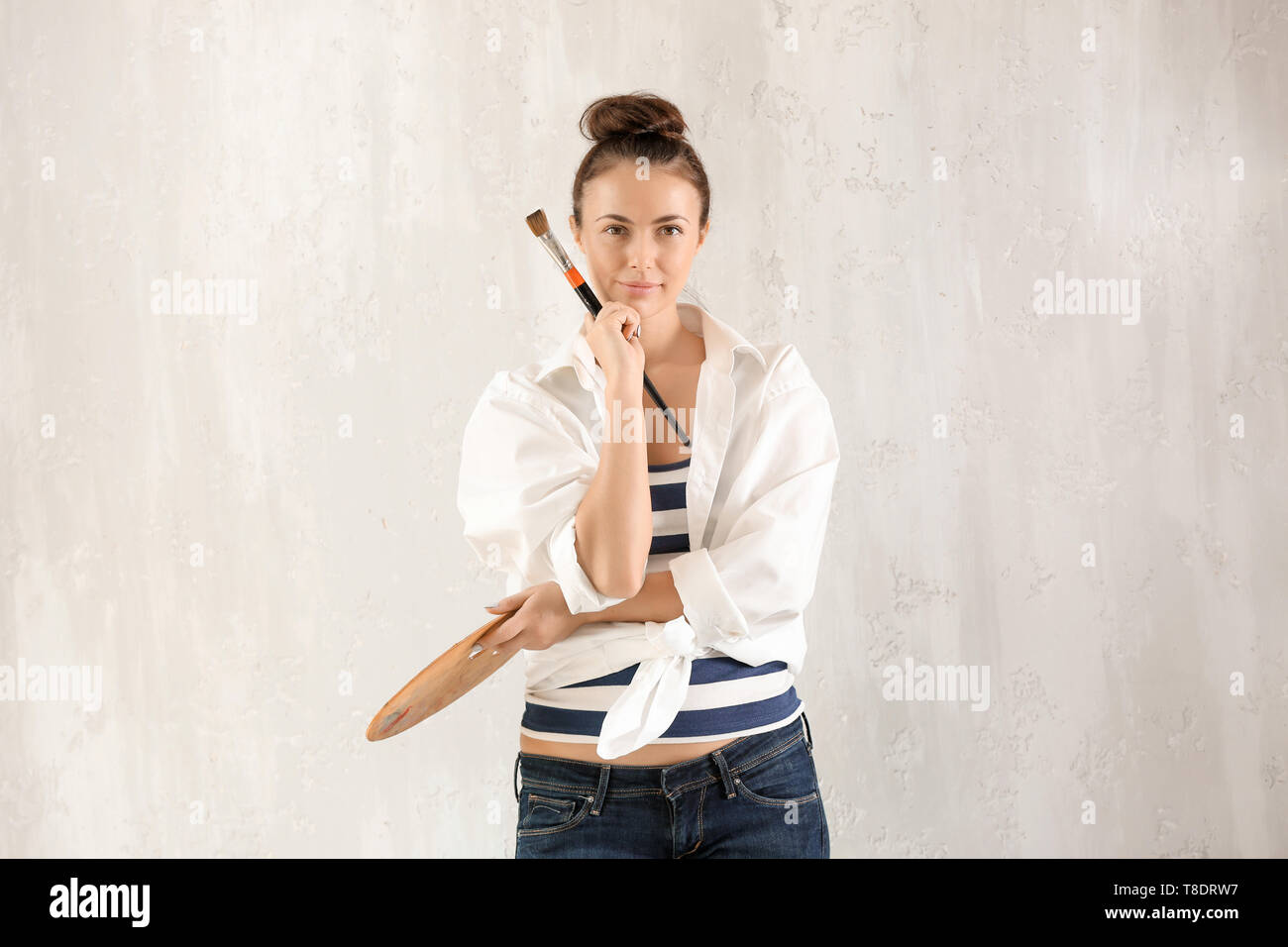Female artist with brush and paint palette on grey background Stock ...