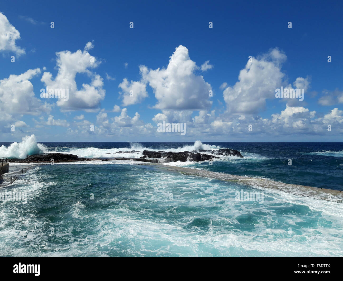 waves at coast with ocean horizon and blue sky and sunny weather Stock Photo