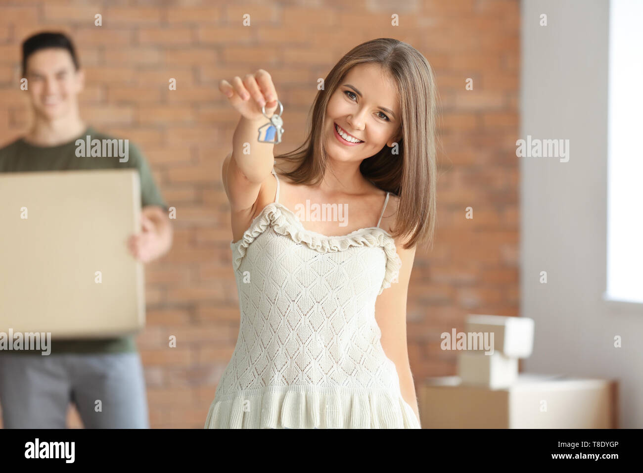 Young couple with key and belongings in their new house Stock Photo - Alamy