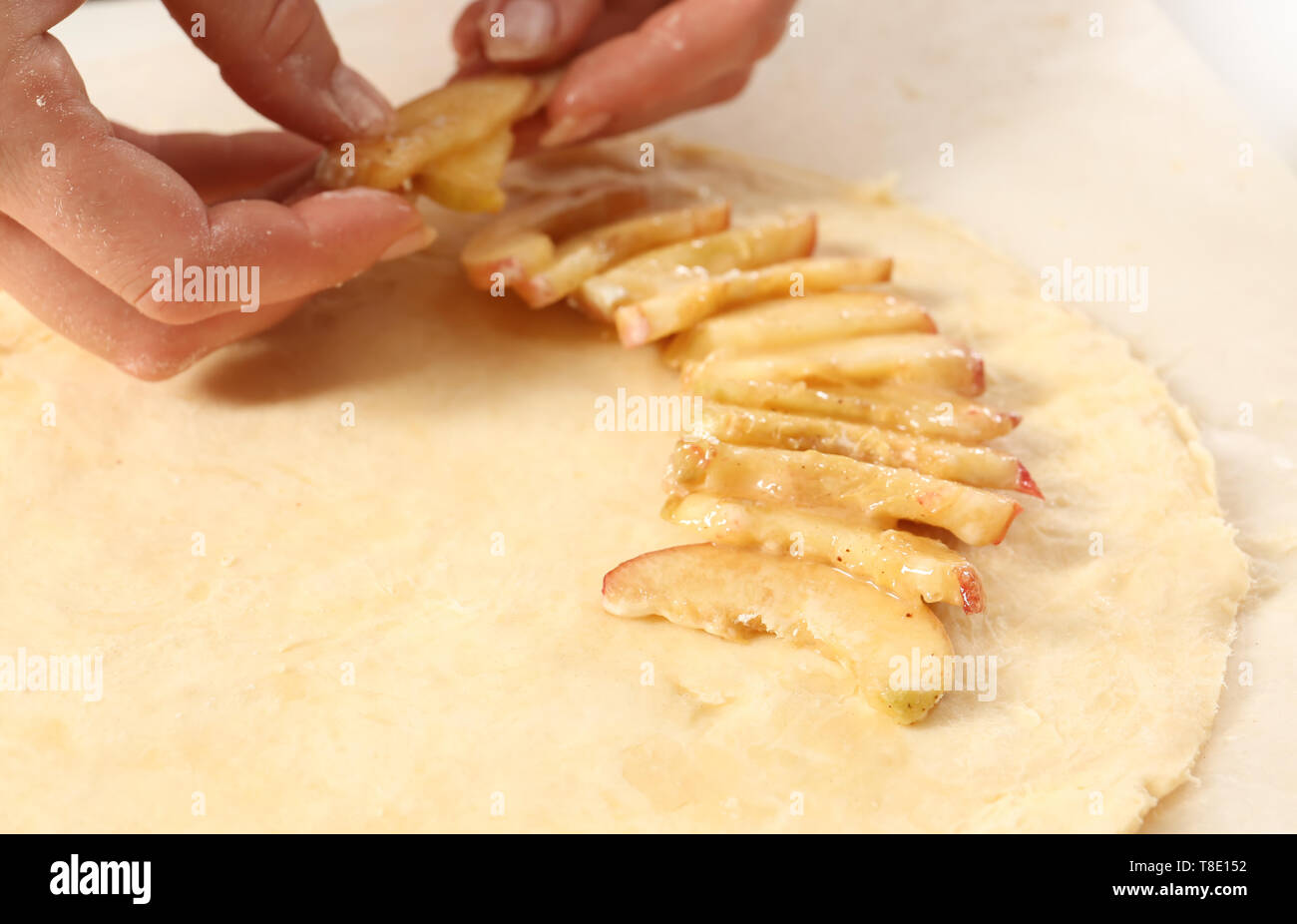 Woman preparing peach galette on table, closeup Stock Photo