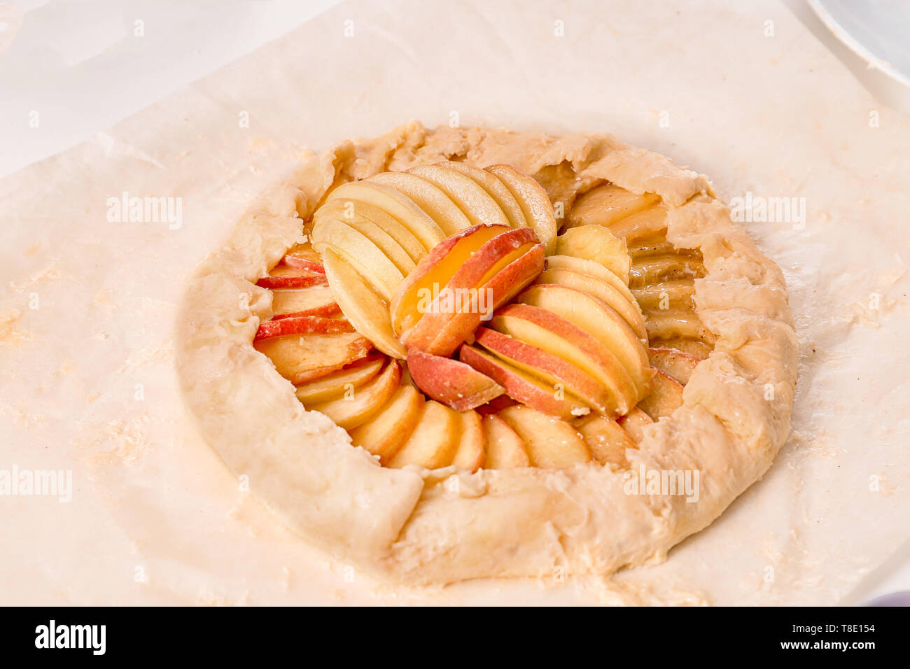 Raw peach galette on parchment paper Stock Photo