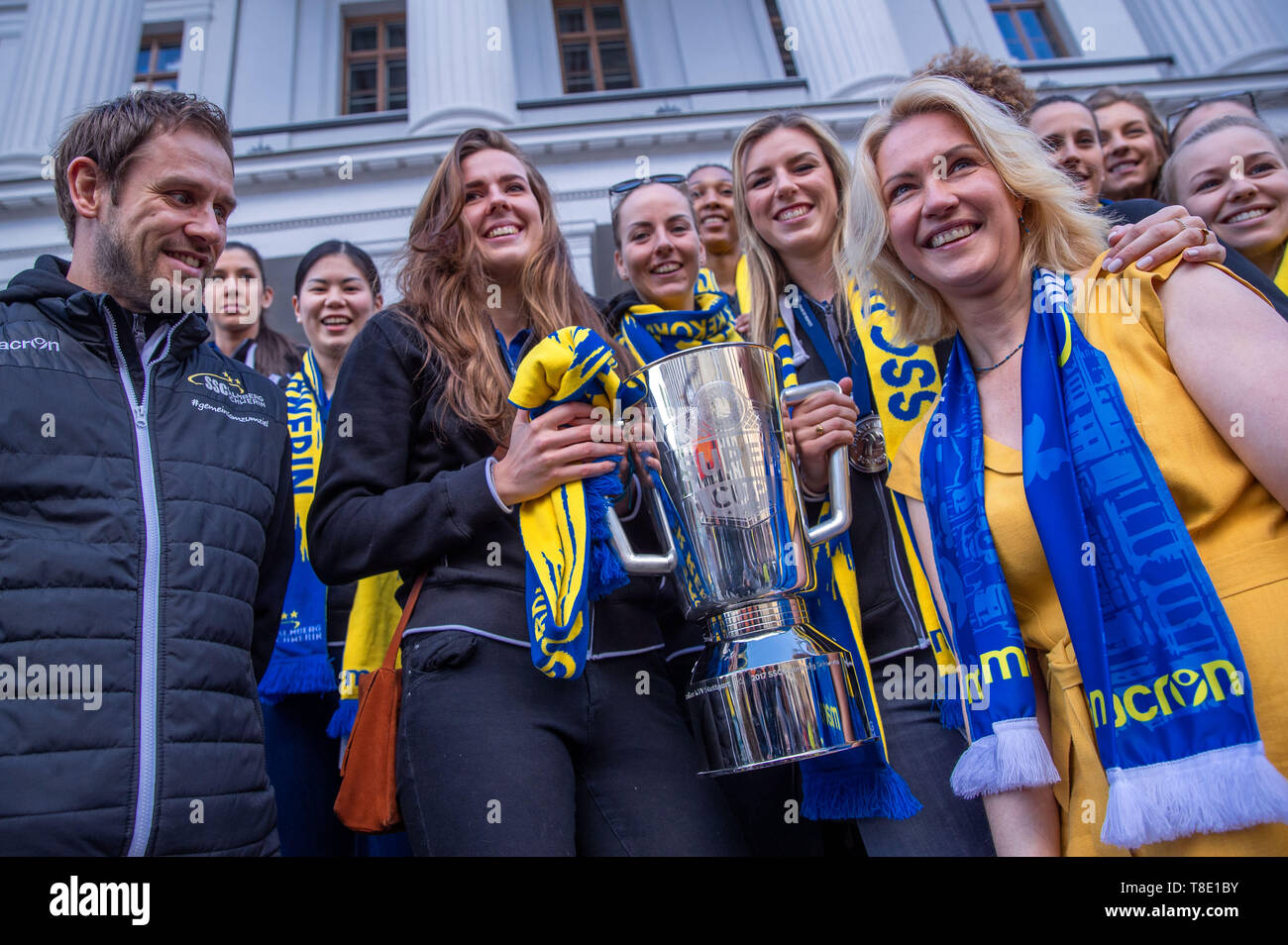 Schwerin, Germany. 12th May, 2019. The Prime Minister of Mecklenburg-Vorpommern, Manuela Schwesig (SPD, r), receives the volleyball players Marie Schölzel (l), Anna Pogany (M) and Britt Bongaerts (4th from right), the trainer Felix Koslowski and the team of the SSC Palmberg Schwerin in front of the State Chancellery. The SSC Palmberg Schwerin lost on 11.05.2019 after five final rounds the last game for the third German champion title in a row. Credit: Jens Büttner/dpa-Zentralbild/dpa/Alamy Live News Stock Photo