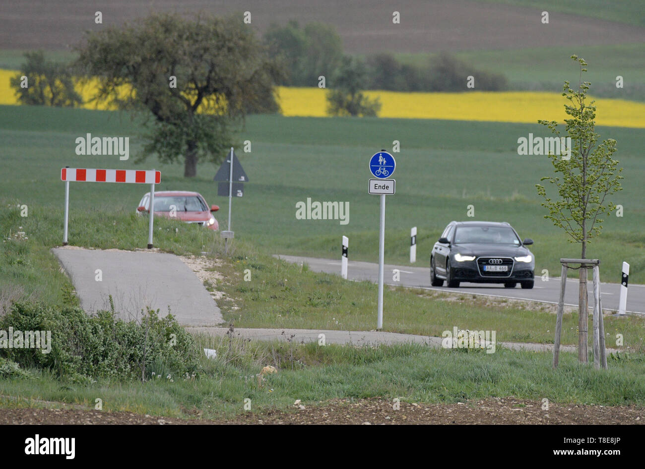 Bachhagel, Germany. 09th May, 2019. A cross beacon signals the end of the cycle path and the national border next to the main road. Between the villages of Bachhagel and Ballmertshofen, the cycle path built by the Free State of Bavaria ends right on the border with Baden-Württemberg. Credit: Stefan Puchner/dpa/Alamy Live News Stock Photo