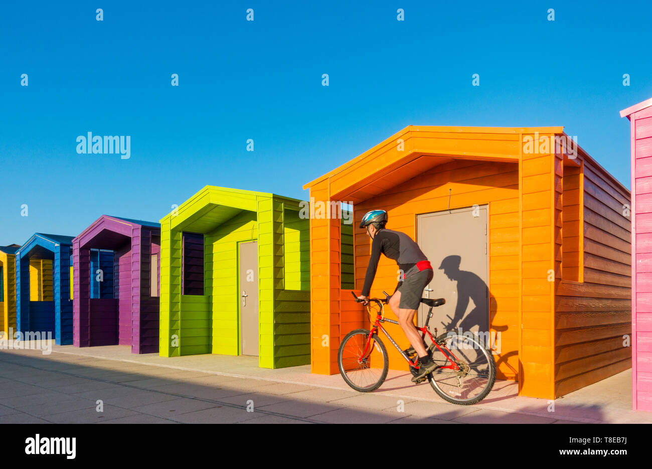 Mountain biker, cyclist riding past colourful beach huts at Seaton Carew. UK Stock Photo