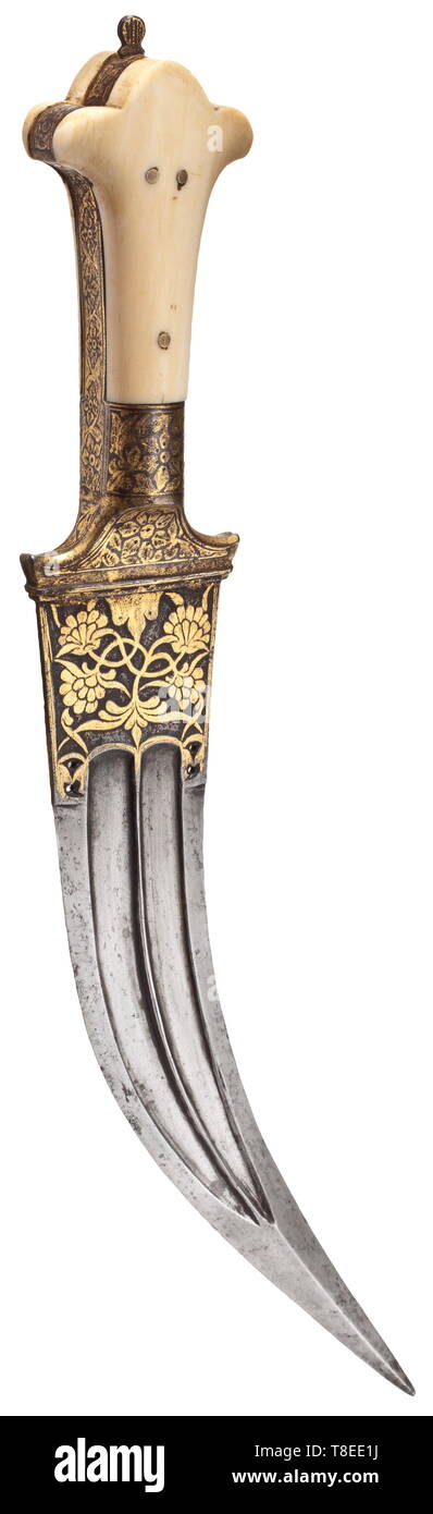 An Indian tiger tooth dagger, circa 1800 Curved, double-edged blade of Wootz Damascus with reinforced quadrangular point and double fullers on both sides. The base of the blade with chiselled and gilt décor of lotus leaves. Finely engraved iron grip ferrule and grip strap with gilt scrolling flowers and leaves. Riveted ivory grips. Length 31 cm. historic, historical, 19th century, Additional-Rights-Clearance-Info-Not-Available Stock Photo