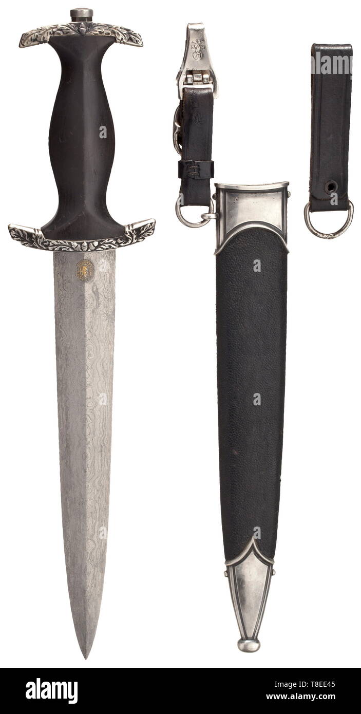 An SS honour dagger with Damascus blade Damascus blade with highly etched, gilt device 'Meine Ehre Heißt Treue' (tr. 'My honour is loyalty') between oak leaf branches, the reverse with the highly etched and gilt maker's logo of Eickhorn, Solingen. Silver grip fittings with a relief-worked oak leaf décor, black wooden grip (small crack) with nickel-silver national eagle and enamelled emblem. The steel scabbard with the original black leather covering (minimal flaws), silver-plated scabbard fittings. With a short, two-piece leather hanger with RZM stamping. Length 37 cm. An e, Editorial-Use-Only Stock Photo