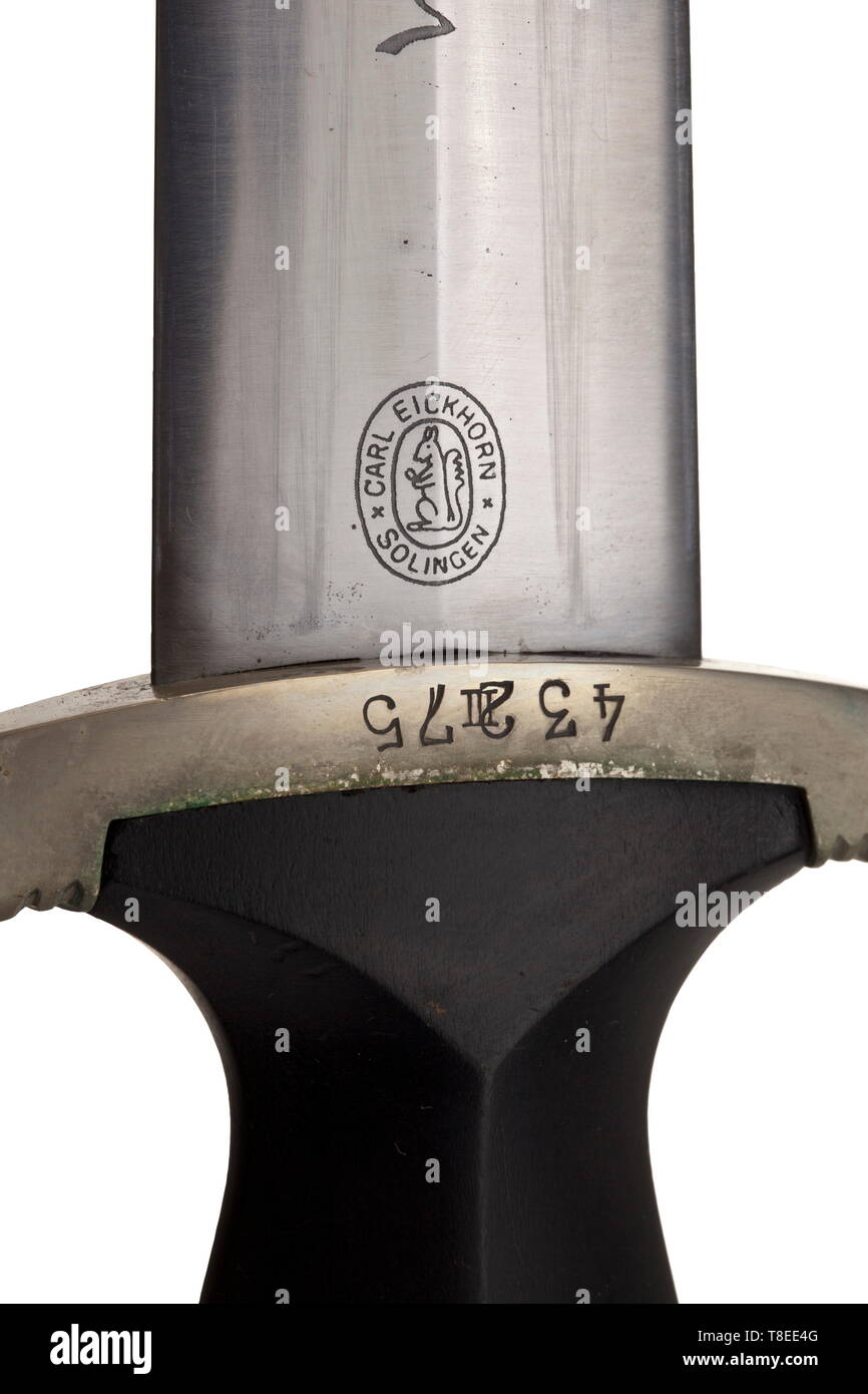 An SS honour dagger M 34 with Röhm dedication The blade with obverse etched device 'Meine Ehre Heißt Treue'(tr. 'My honour is loyalty'), the reverse with the logo of Eickhorn, Solingen and dedication 'In herzlicher Kameradschaft Ernst Röhm'. Black wooden grip with nickel silver national eagle and enamelled SS emblem. The grip fittings of non-ferrous metal, the cross-guard with struck 'III' surmounted by the SS number '43275'. Black burnished iron scabbard with silver-plated non-ferrous metal fittings, vertical hanger. Length 37 cm. A very rare and matching dagger in good co, Editorial-Use-Only Stock Photo
