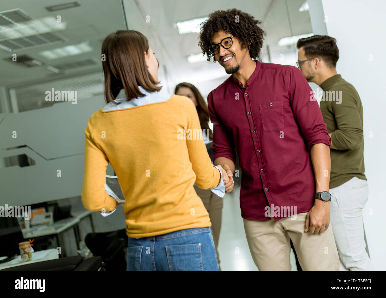 Happy and successful young people are standing in a modern office Stock ...