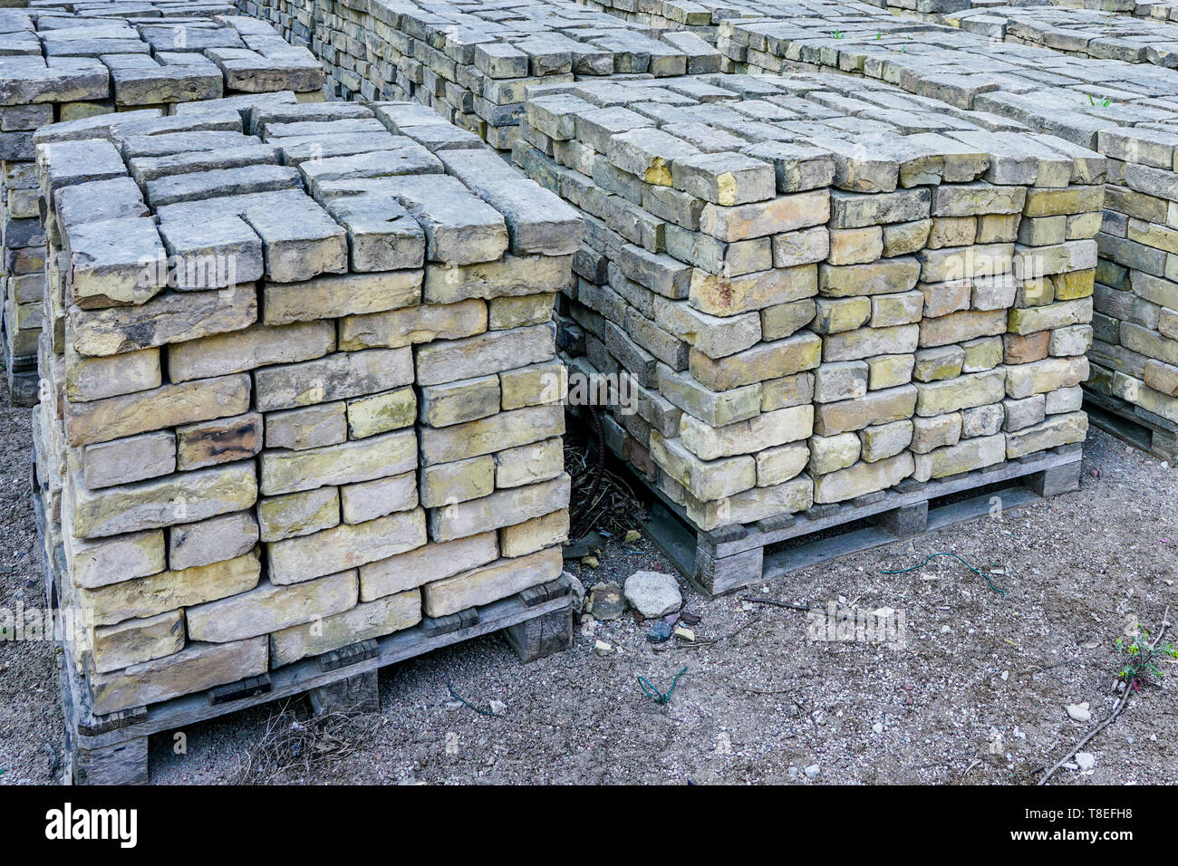old used bricks, stacked into cubes on pallets Stock Photo