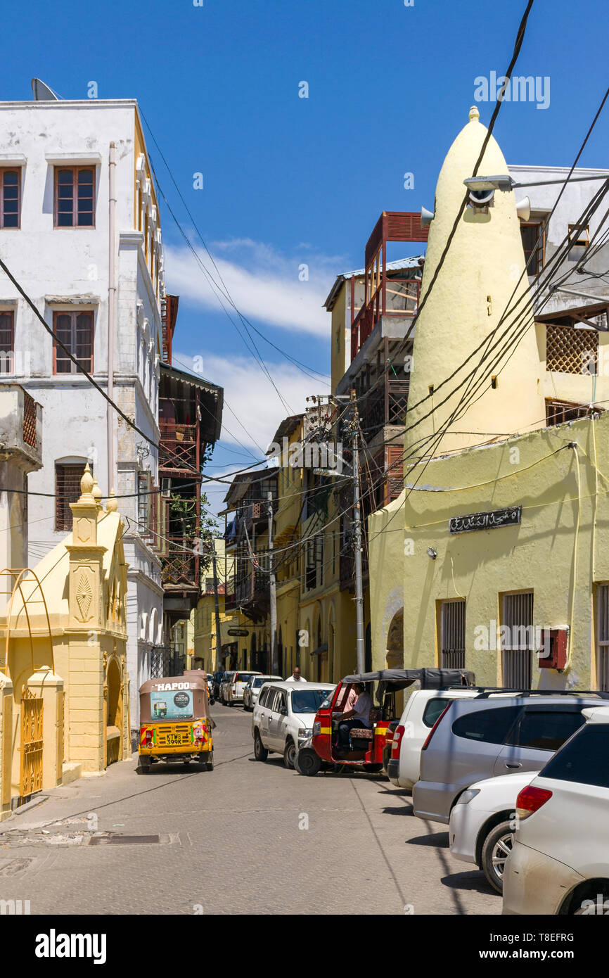 The Old town area of Mombasa with buildings and vehicles lining the street, Kenya Stock Photo