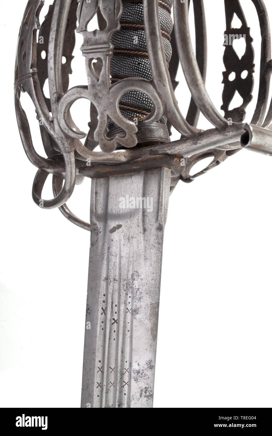 A Scottish basket-hilted broadsword circa 1780. With earlier blade, probably late 17th or early 18th century, of broad robust form, cut with a central fuller running over most of its length on both sides, flanked by a slightly shorter pair of fullers, cut with additional short fullers at the ricasso, and inscribed 'Andrea Ferara' in stamped letters framed within a series of decorative marks on both sides at the forte, iron basket-guard of Glasgow type formed of symmetrical oval bars carrying pierced linear-engraved panels, fluted hemispherical po, Additional-Rights-Clearance-Info-Not-Available Stock Photo