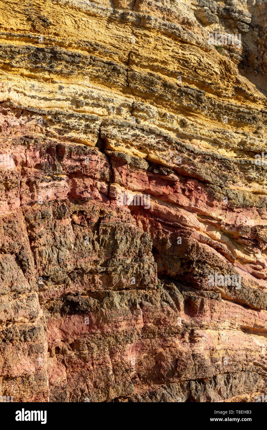 Cliff face showing multi-colored sediments in the Costa Vicentina natural park at the Atlantic Ocean at the Algarve, Portugal. Stock Photo
