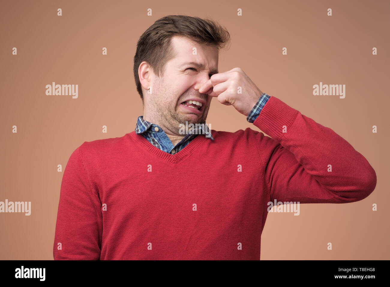 Man plugs nose as smells something stink Stock Photo