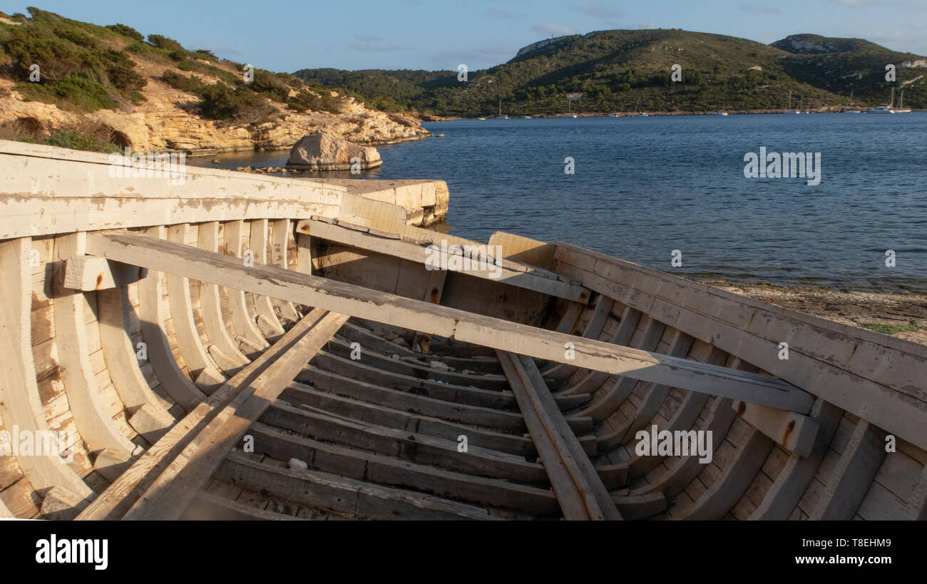 landscape with abandoned fishing boat on the shore. Island of Cabrera, Mallorca at sunset. Summer Vacation. August. Wooden boat.Mediterranean Sea Stock Photo