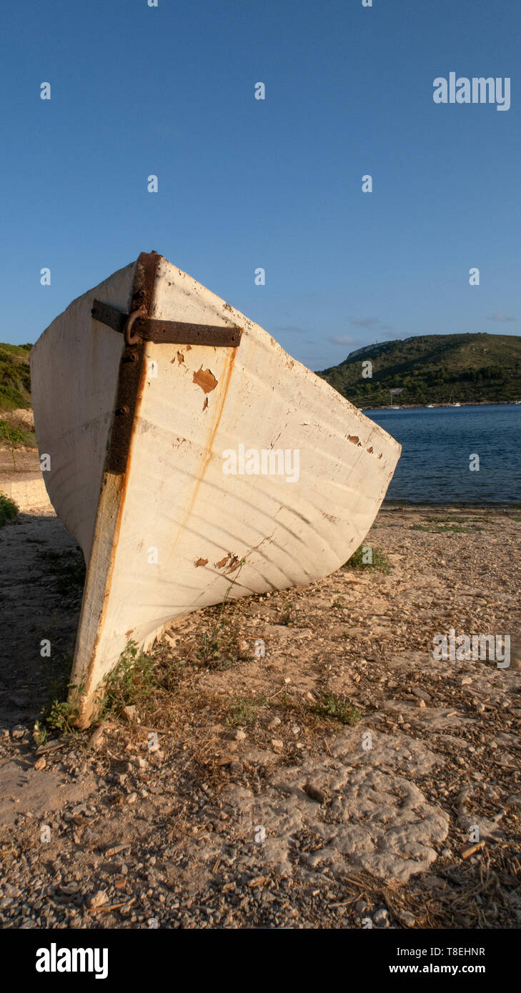 landscape with abandoned fishing boat on the shore. Island of Cabrera, Mallorca at sunset. Summer Vacation. August. Wooden boat.Mediterranean Sea Stock Photo
