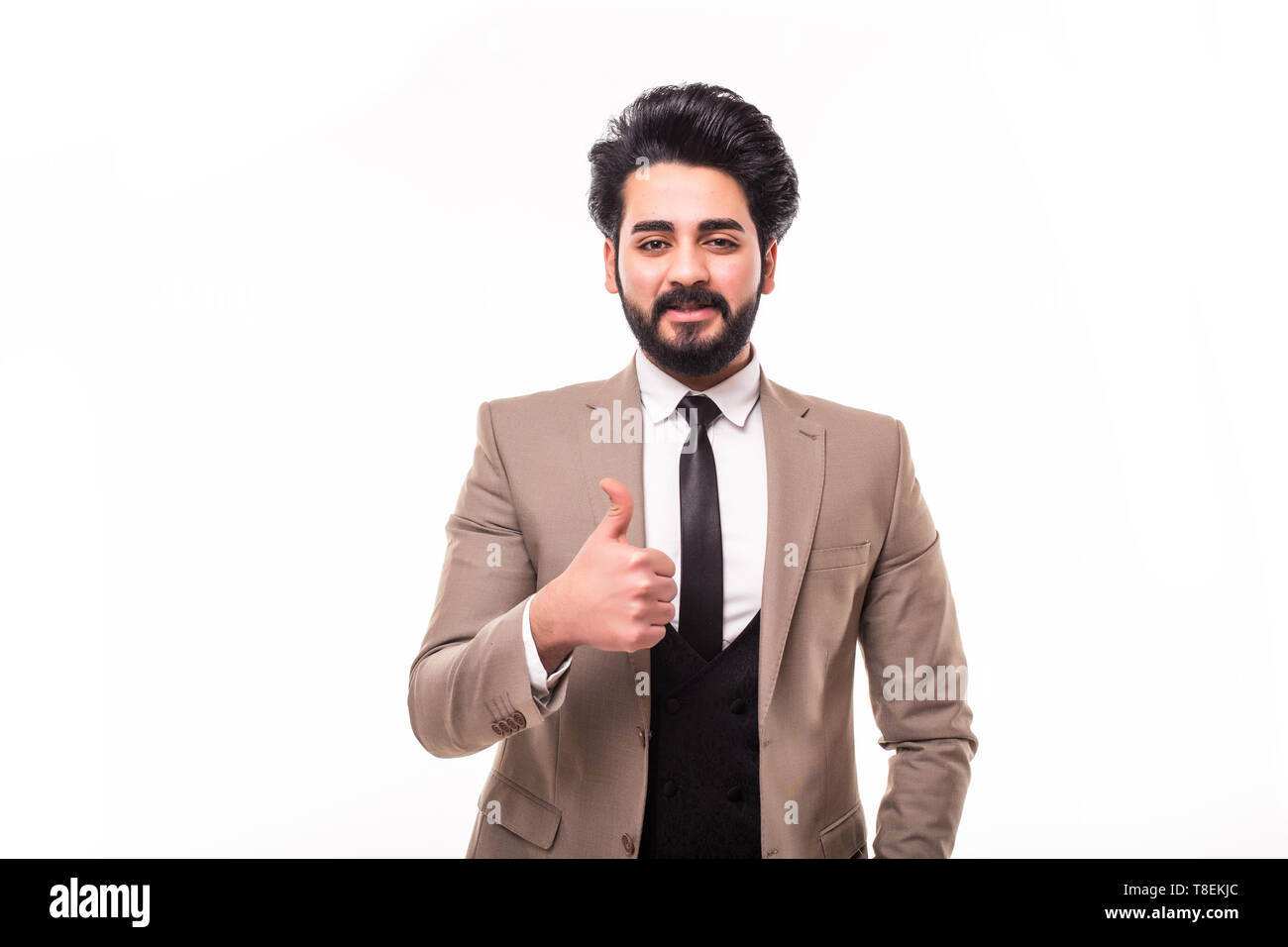 Arab handsome young businessman with hand in pocket smiling and thumbs up on white background Stock Photo