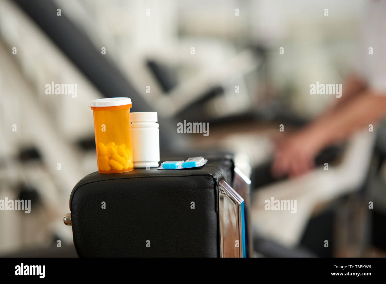 Plastic bottles with tablets. Bottle with medication on blurred fitness gym background. Nutrition supplement, body care. Stock Photo