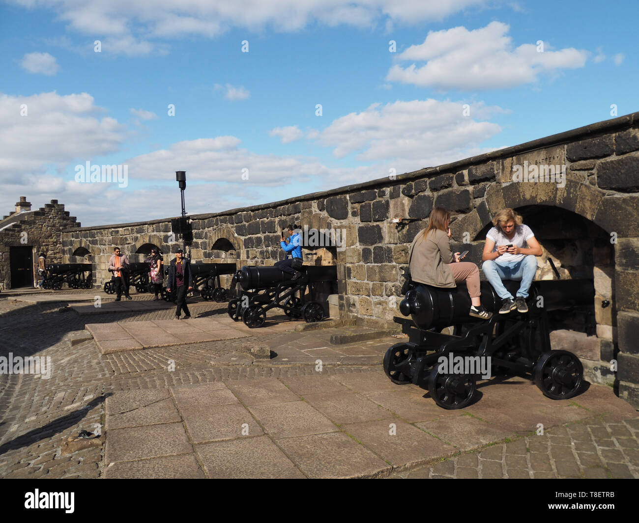 EDINBURGH - SEPTEMBER 2016:  Tourists enjoy exploring the cannon aiming out through gun ports on the battlements of Edinburgh Castle. Stock Photo