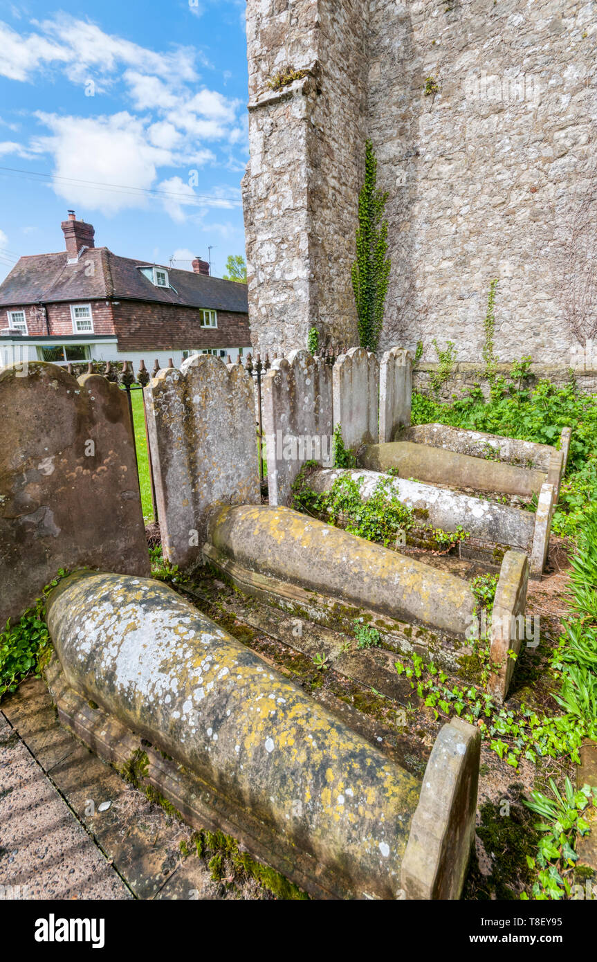 Typical Kentish coffin-shaped graves of one family in the churchyard of St George's church, Ivychurch on Romney Marsh. Stock Photo
