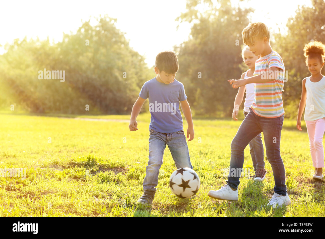 Cute little children playing football outdoors Stock Photo - Alamy