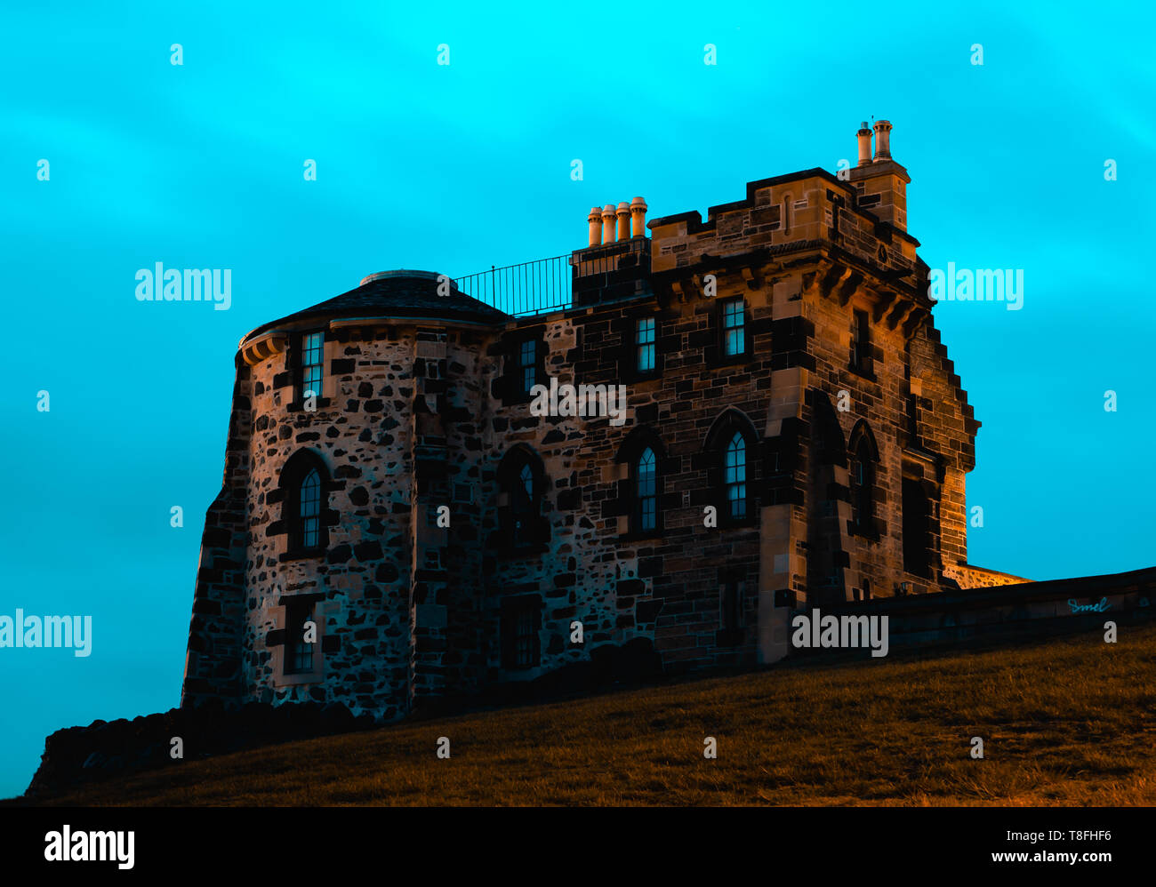 Sandstone building with arched windows, chimneys and circular side on Calton Hill in Edinburgh, Scotland. Stock Photo