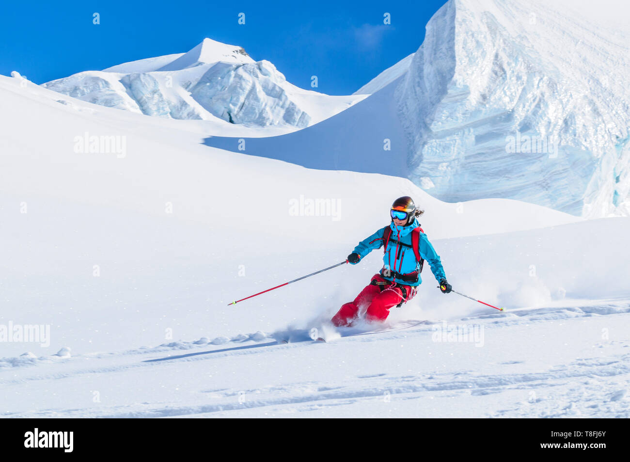 Female freeskier skiing in backcountry on fantastic Monte Rosa glaciers Stock Photo